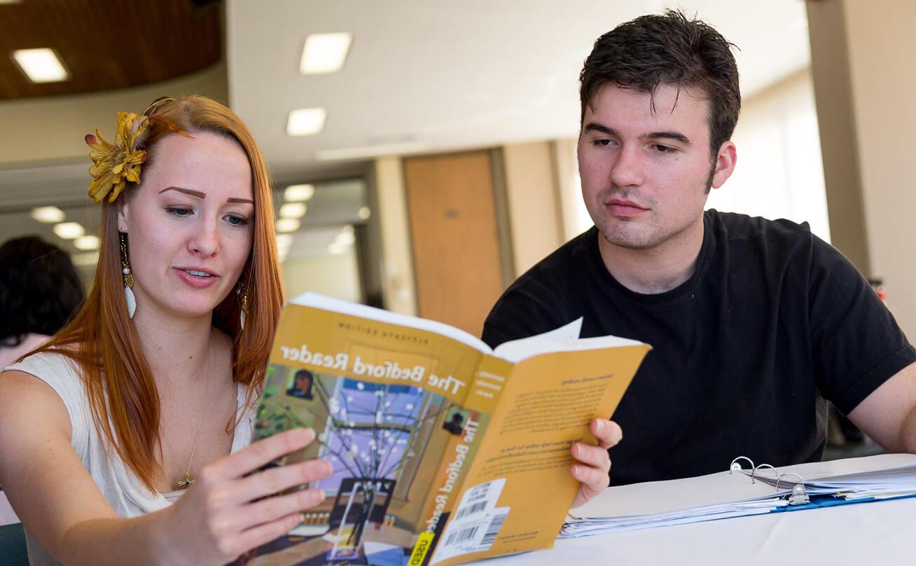 Male and Female student studying The Bedford Reader